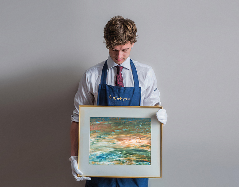 A man Standing holding a painting